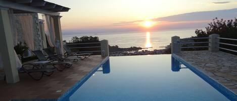 Outdoor pool, an infinity pool, pool umbrellas, pool loungers