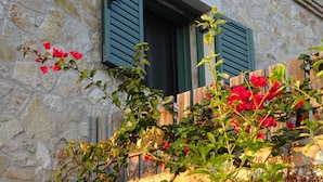 A stone building with a window and shutters. - Artist's Villa Red Rose (Paxos)