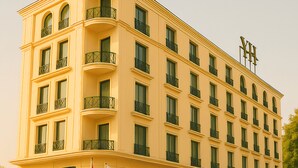 Un hotel de varios pisos con balcones, una bandera y un letrero que dice "YUKSEL HOTEL".