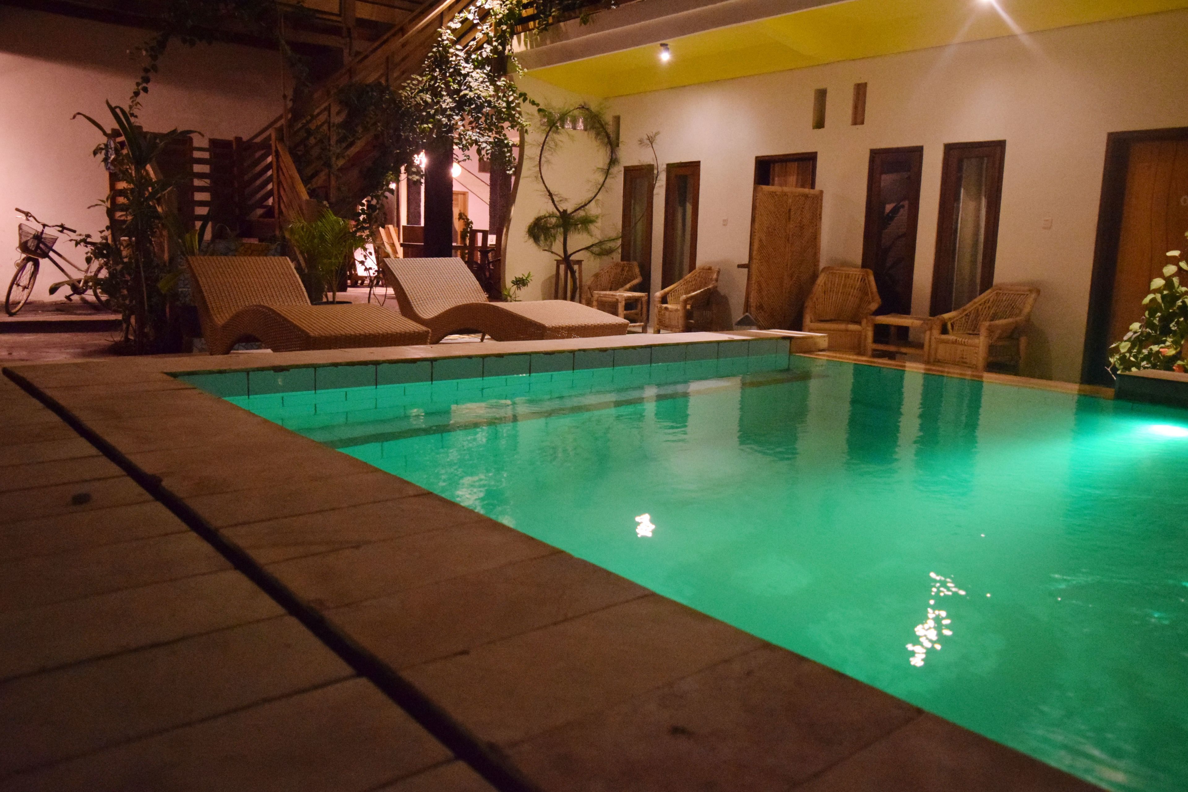A swimming pool with lounge chairs and a bicycle.
