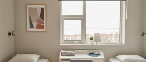 Un dormitorio con dos camas, un escritorio y una ventana con vistas.