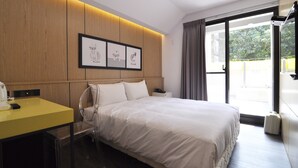 Una habitación de hotel moderna con cama, escritorio y vistas al exterior.