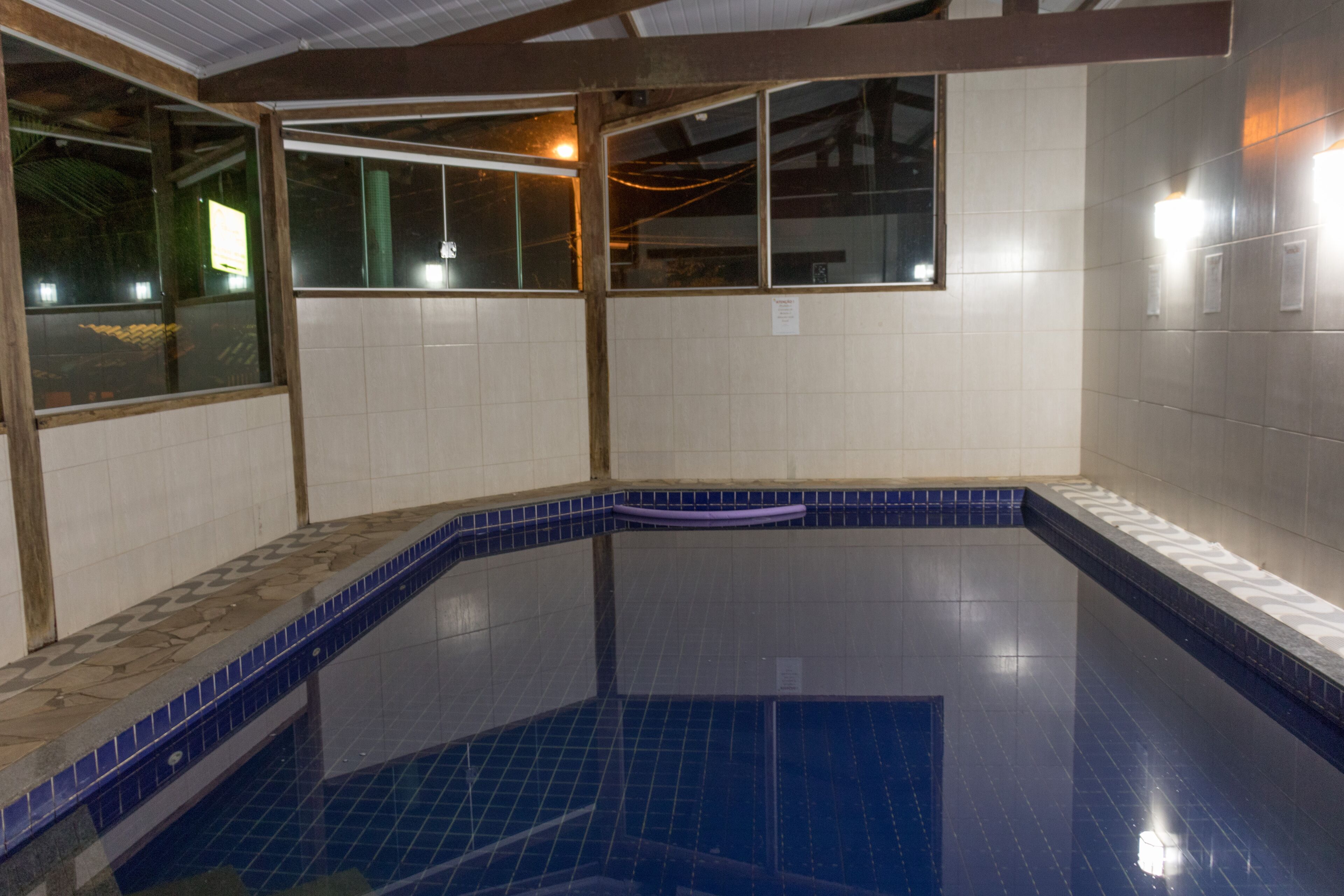 Piscina con paredes de azulejos y diseño en esquina.