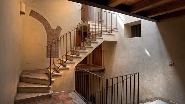 A staircase with a metal railing leading to an upper floor. - Verona For Rent La Colombina (Verona)