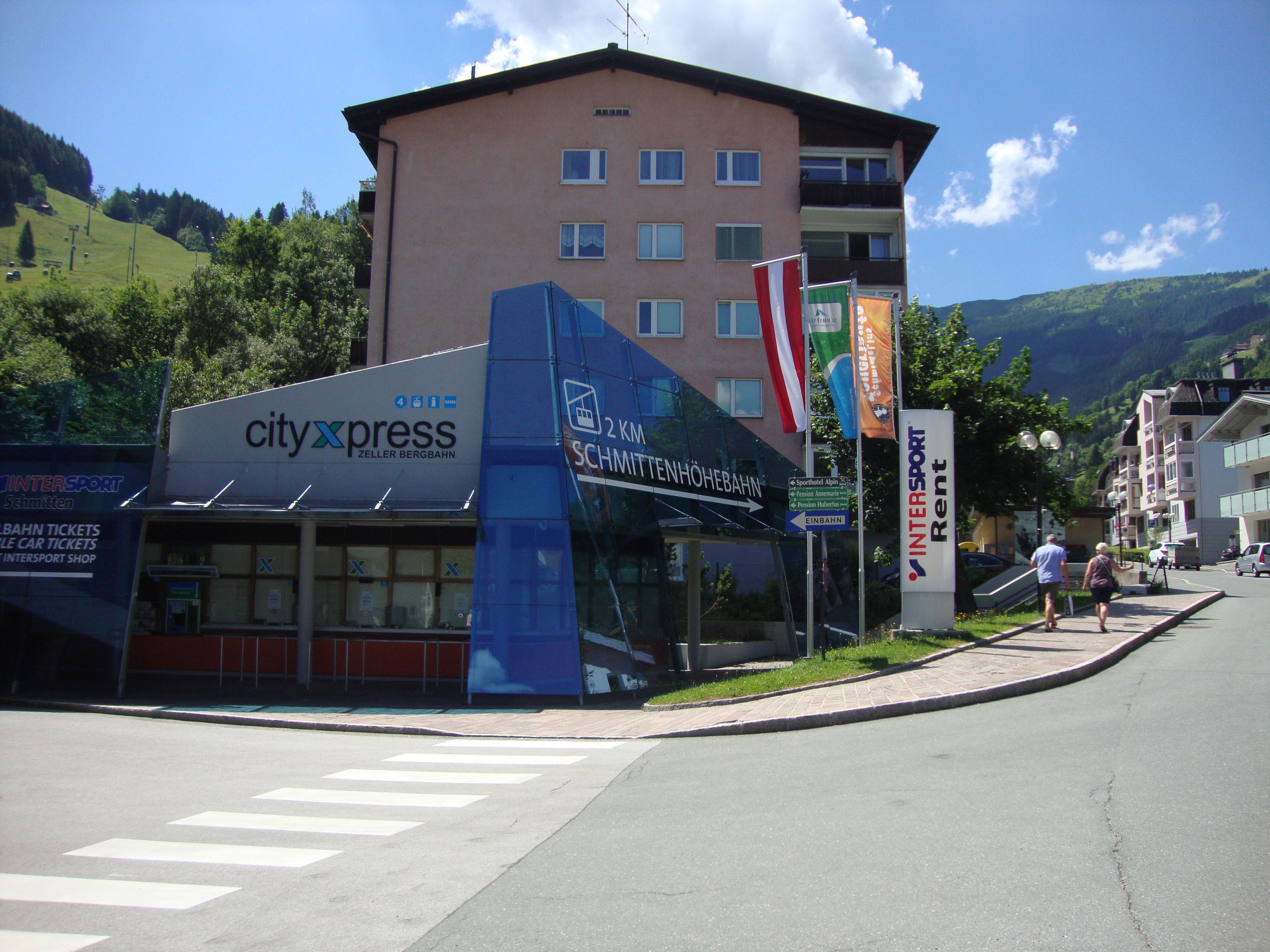A building with a 'cityxpress' sign, a '2 km' distance marker, and a 'Schmiden' sign.