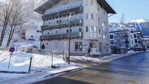 A multi-story hotel with a modern architectural design, featuring balconies and a ski resort in the background. - Schlafgut Küssler Zell am See (Zell am See)