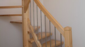 A wooden staircase with metal railings and a plain wall in the background. - Schlafgut Küssler Zell am See (Zell am See)