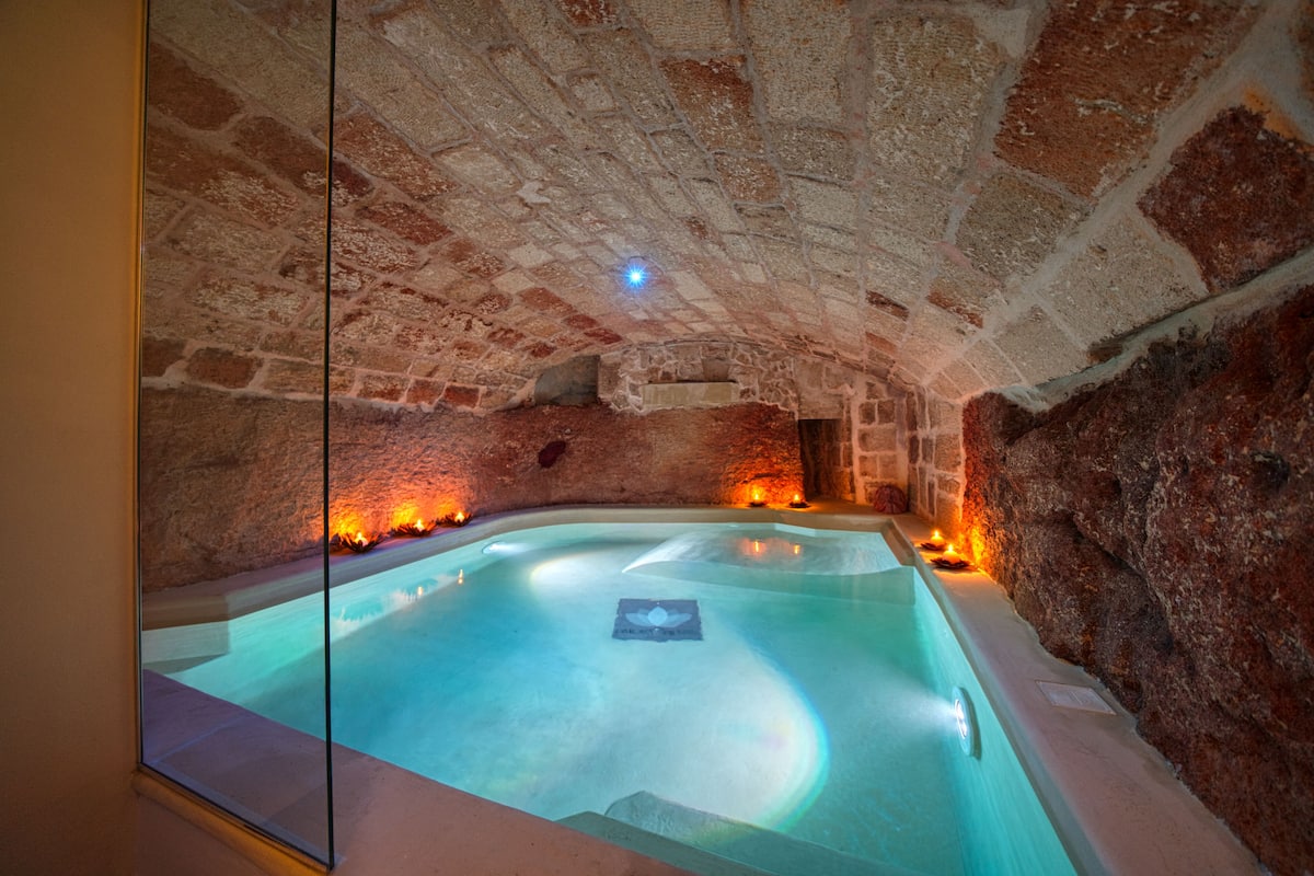 A spa with a stone interior and a pool.