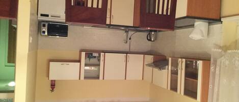A compact kitchen with a microwave, a sink, and cabinets.