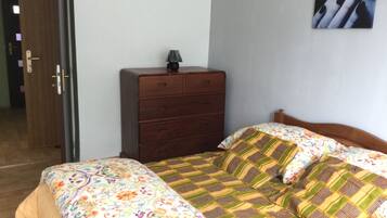 Un dormitorio con cama, cómoda y puerta.