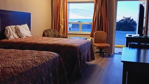 A hotel room with two beds, a desk, a chair, and a window with curtains. - Sheldon's Motel by OYO Keysville Near Hwy 360 (Keysville)
