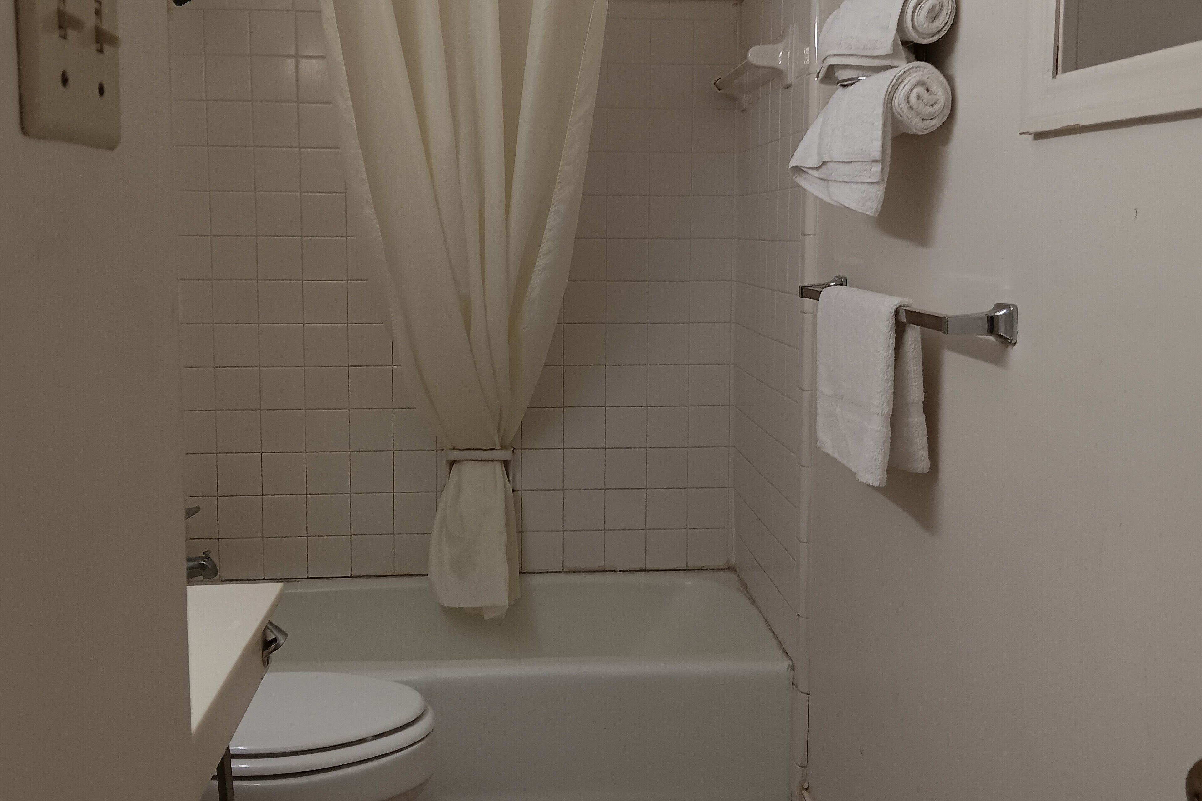 Un baño con inodoro, bañera y cortina de ducha.
