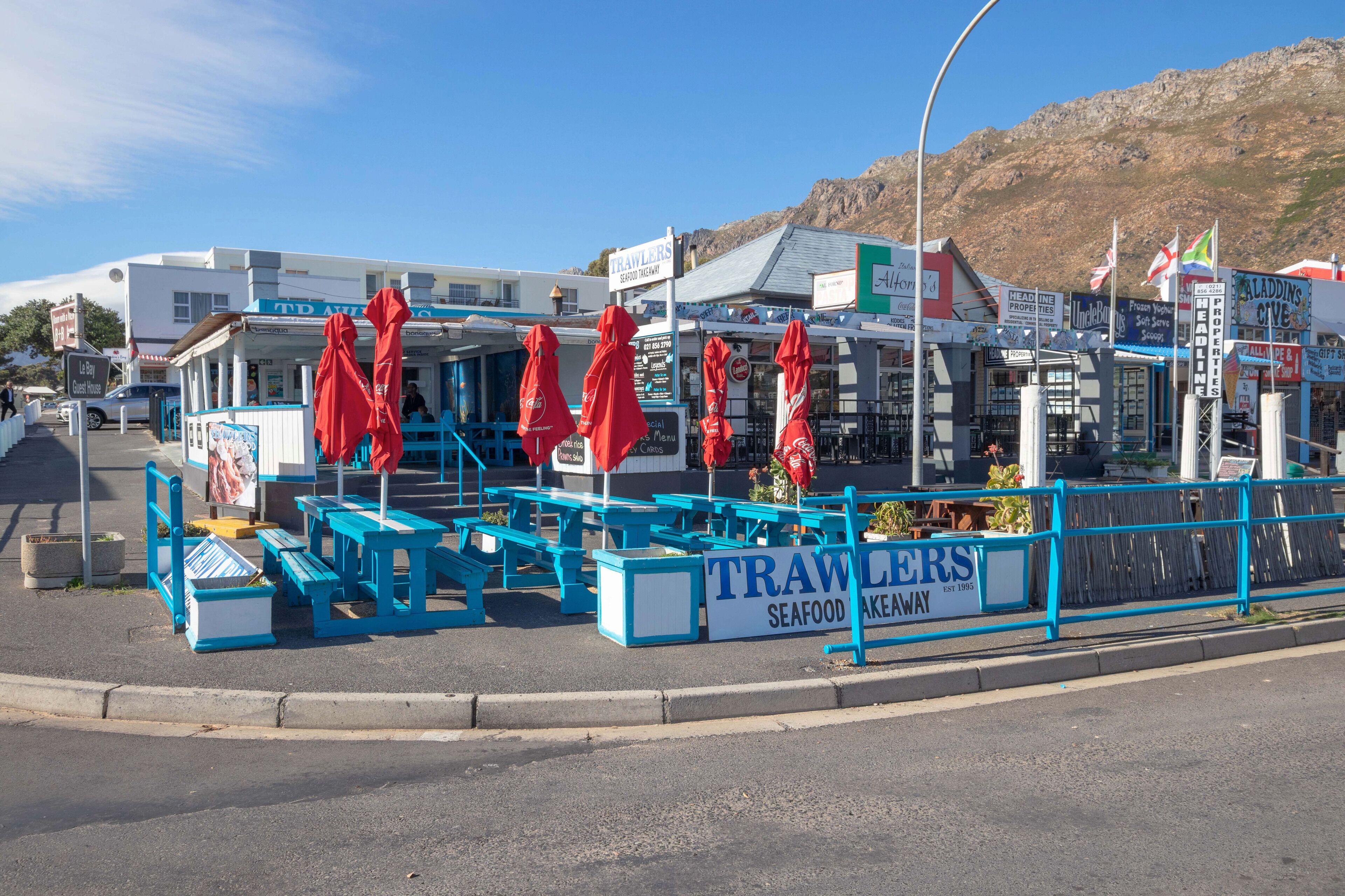 A seafood restaurant with outdoor seating and a sign reading "TRAWLERS SEAFOOD".