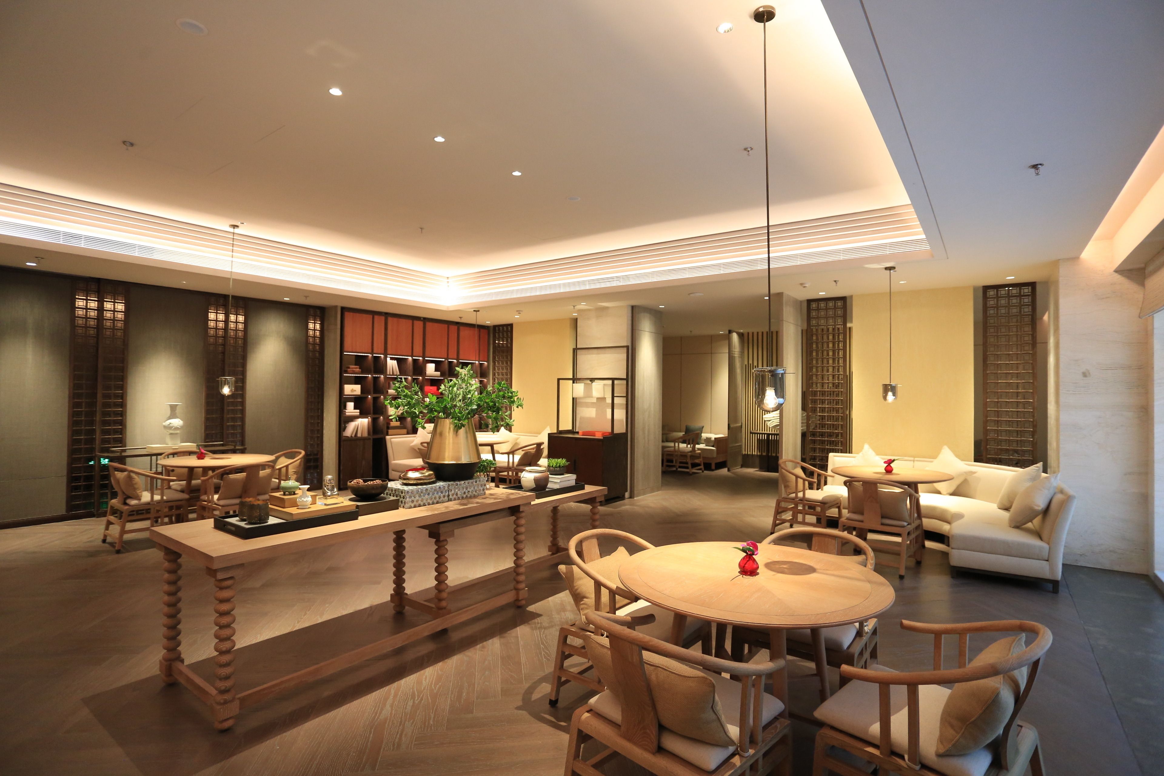 A spacious living area with a central wooden table, surrounded by comfortable seating.