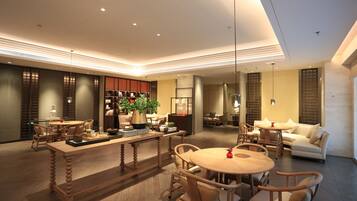 A spacious living area with a central wooden table, surrounded by comfortable seating.