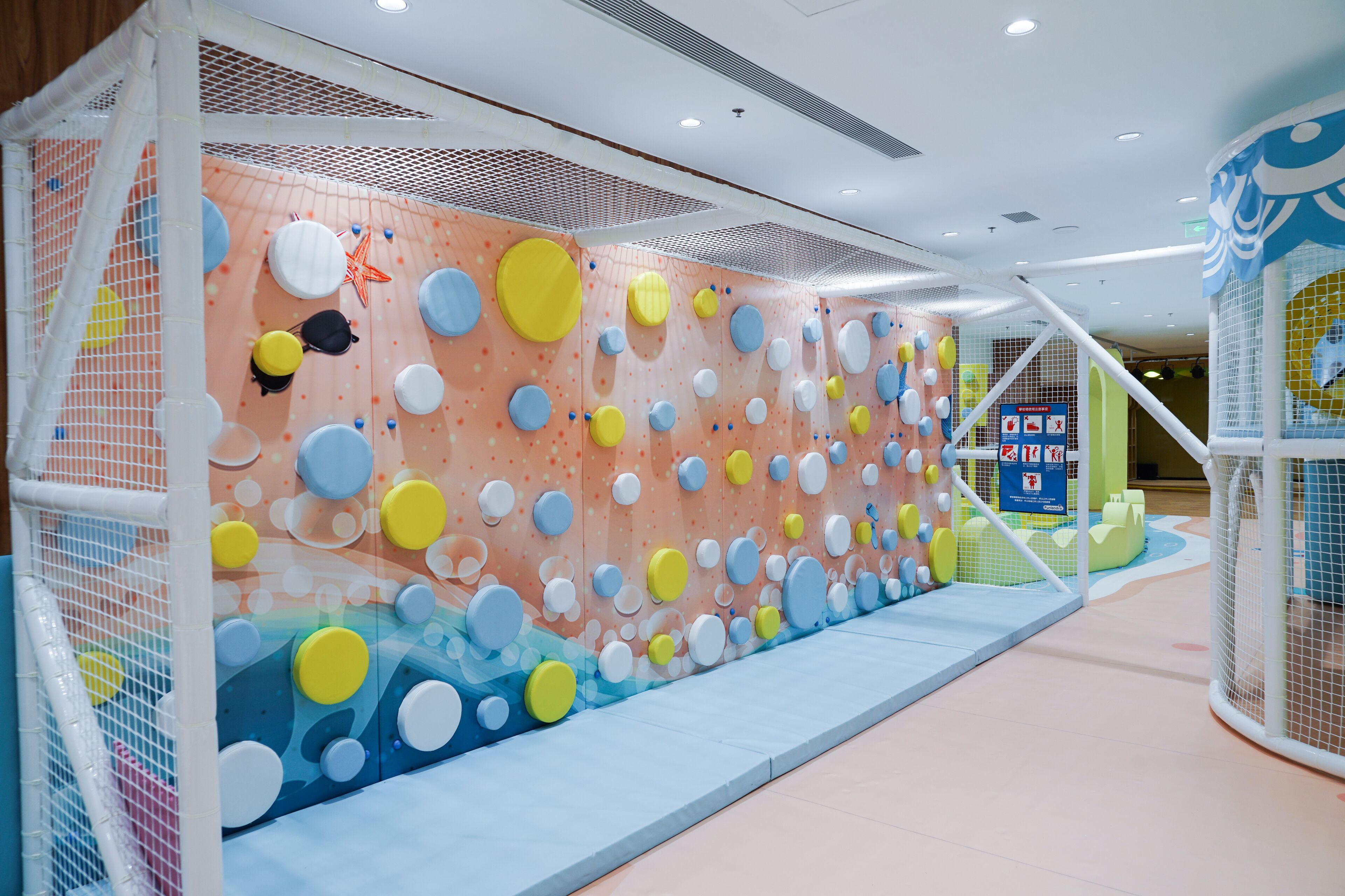 A children's play area with climbing walls and soft play surfaces.