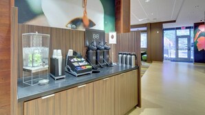 A reception area with a coffee station, a glass display case, and a sign with 'BB' branding. - Fairfield Inn & Suites by Marriott Asheville Tunnel Road (Asheville)