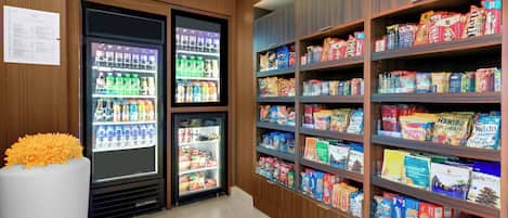 A grocery store with refrigerated sections and shelves stocked with various food products.