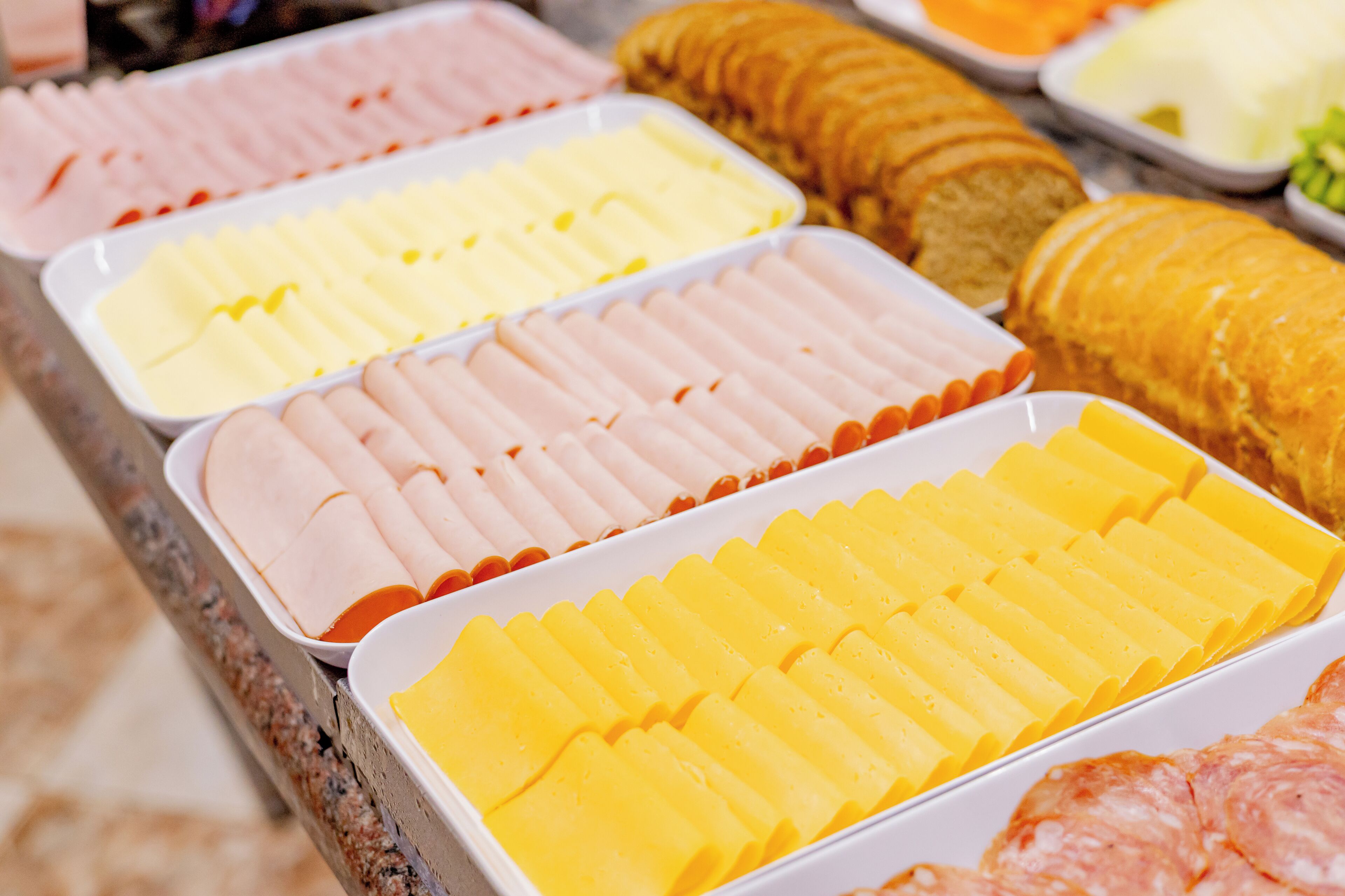A buffet with various food items including sliced meats and cheeses.