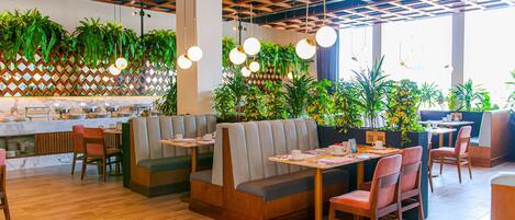 Un interior de restaurante moderno con suelo de madera, cabinas y mesas.