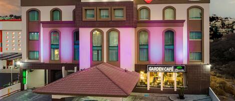 Un hotel con un letrero que dice "Best Western PLUS" y un letrero que indica "Garden Café" debajo.
