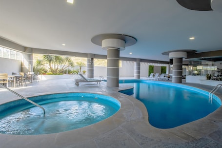 Indoor pool, pool loungers. Best Western Plus Santa Cecilia Pachuca