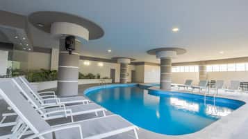 Una piscina cubierta, tumbonas