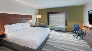 A hotel room with a large bed, a desk with a chair, a small table, and a window with blinds. - Holiday Inn Express & Suites Tulsa South - Woodland Hills by IHG (Tulsa)