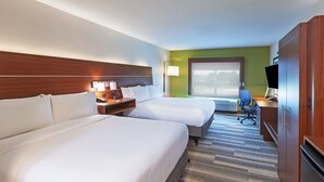 Une chambre d’hôtel avec deux lits, un bureau avec une chaise, une télévision et une grande fenêtre.
