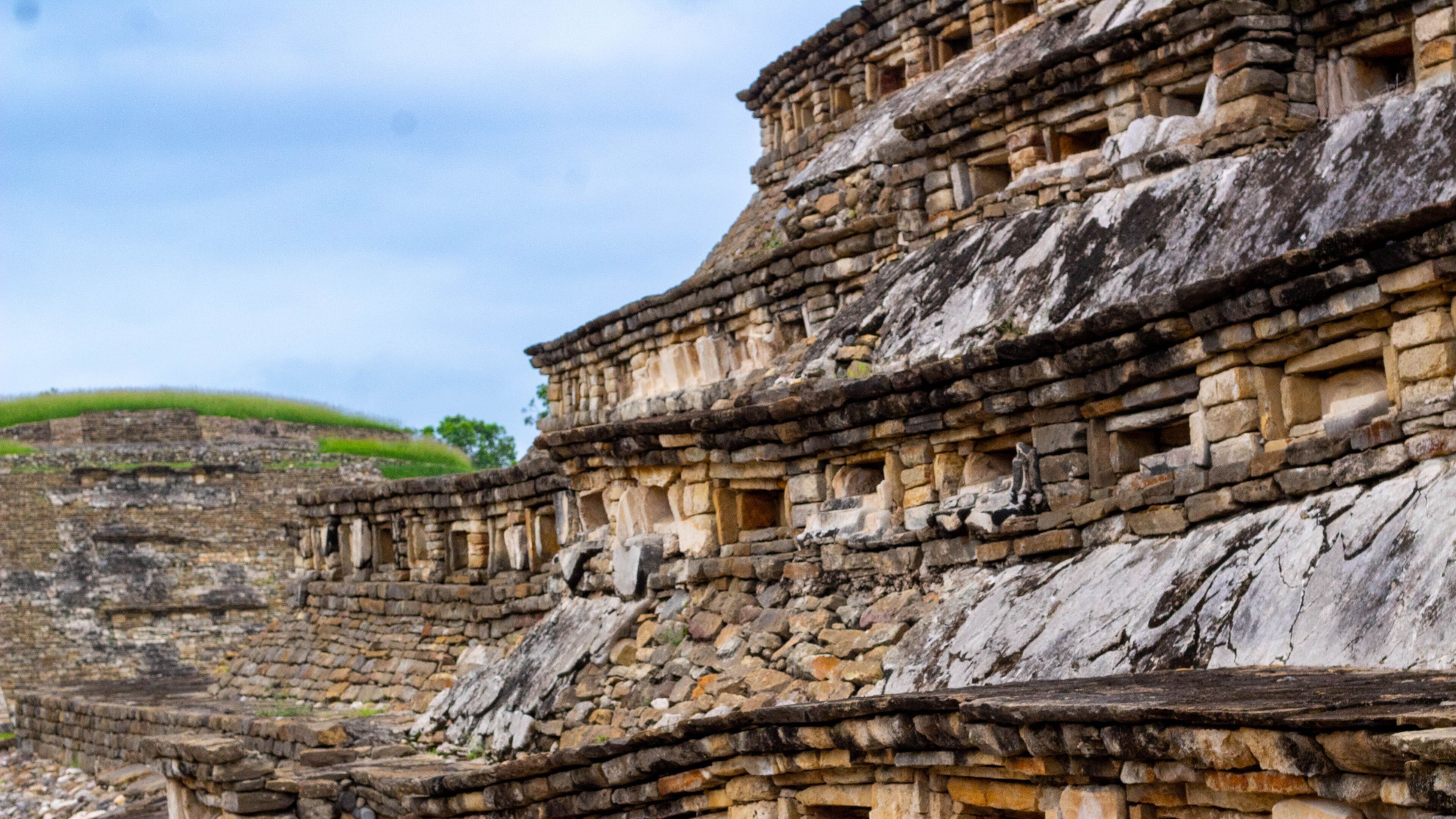 An ancient stone structure with multiple levels and rectangular openings.