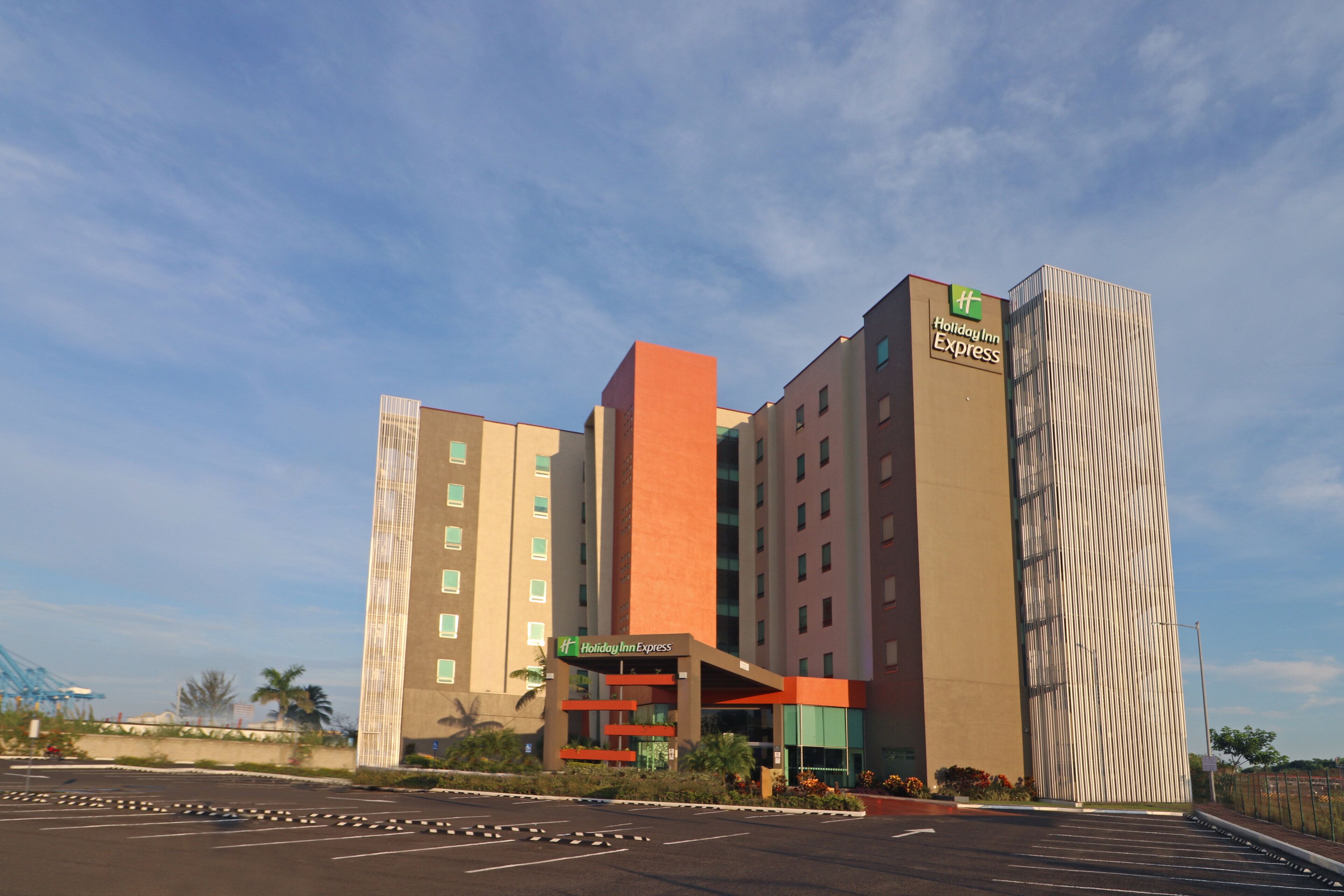 Un hotel Holiday Inn Express con un diseño moderno, que cuenta con varios pisos y una estructura vertical destacada.