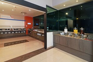 Een moderne keuken met buffettafels, een groot raam en een schoon, goed verlicht interieur.