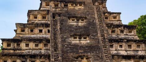 A large, multi-tiered stone structure with multiple levels and windows.