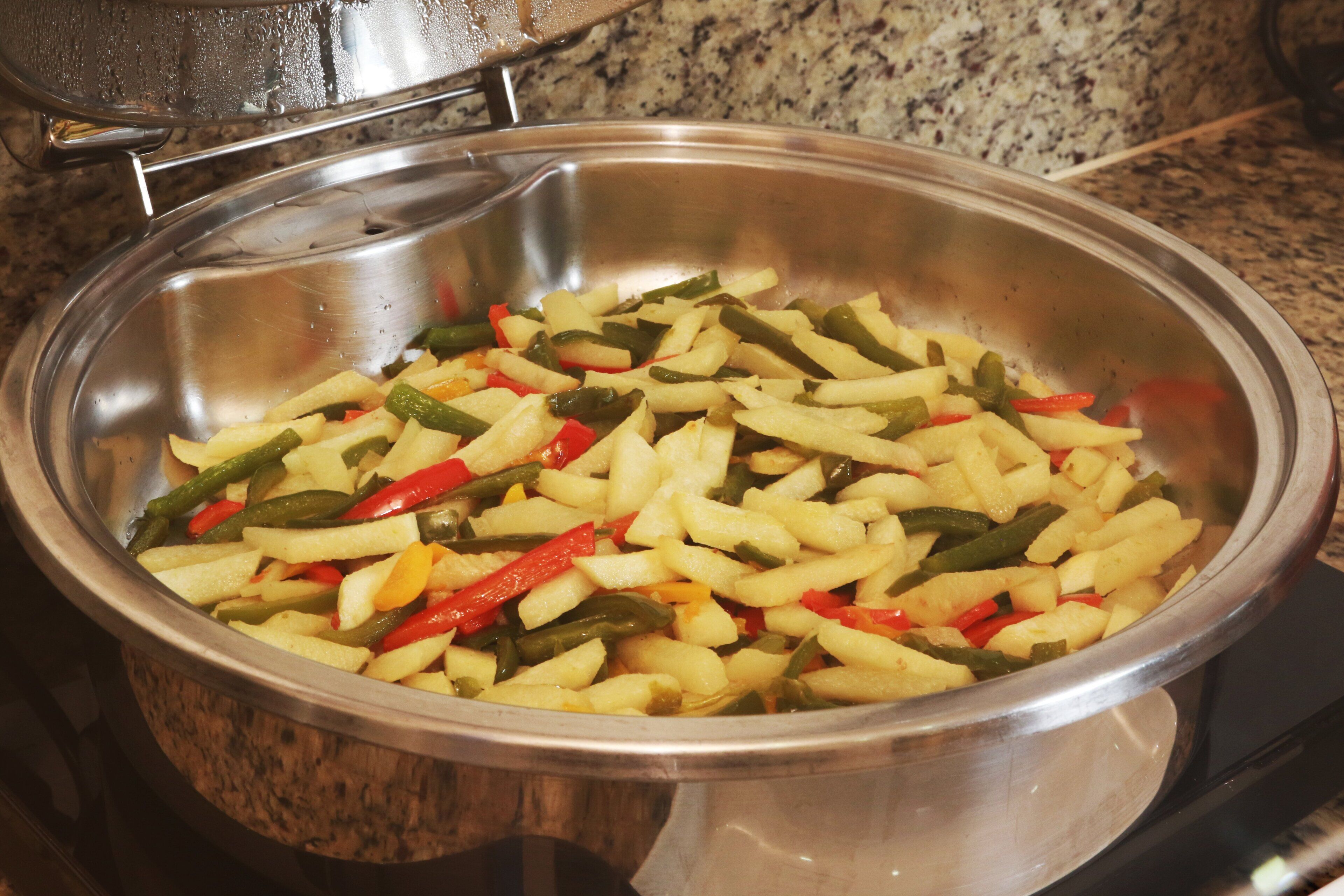 A stainless steel pot containing sliced vegetables.