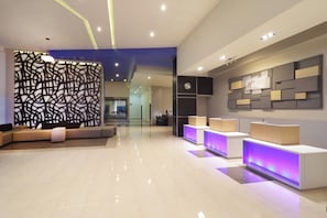 A modern reception area with a seating area, a reception desk, and a wall-mounted clock. - Holiday Inn Express Tuxpan by IHG (Tuxpan)
