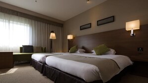 A hotel room with two beds, a desk, and two wall-mounted lamps. - Hotel Tsu Center Palace (Tsu)