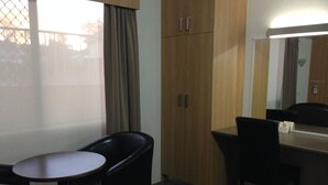 A hotel room with a bed, a desk, a chair, and a wardrobe. - Albury Regent Motel (Albury)