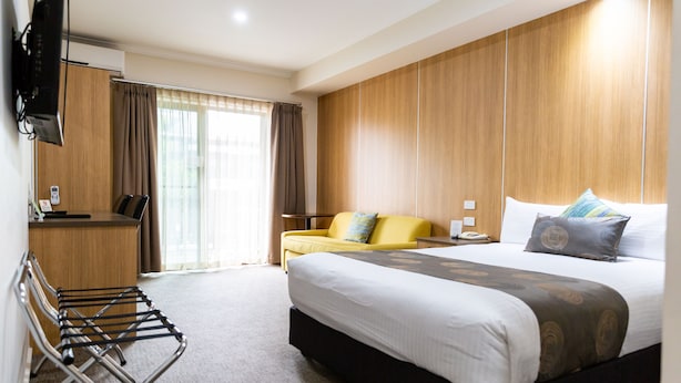 A hotel room with a bed, a desk, a chair, and a TV. - Albury Regent Motel (Albury)