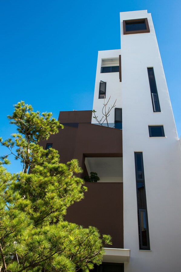 A modern building with a white facade and brown accents, featuring multiple windows and balconies. - Timia (Hualien City)