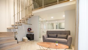 A modern living room with a grey sofa, a wooden coffee table, and a staircase with a minimalist design. - Timia (Hualien City)