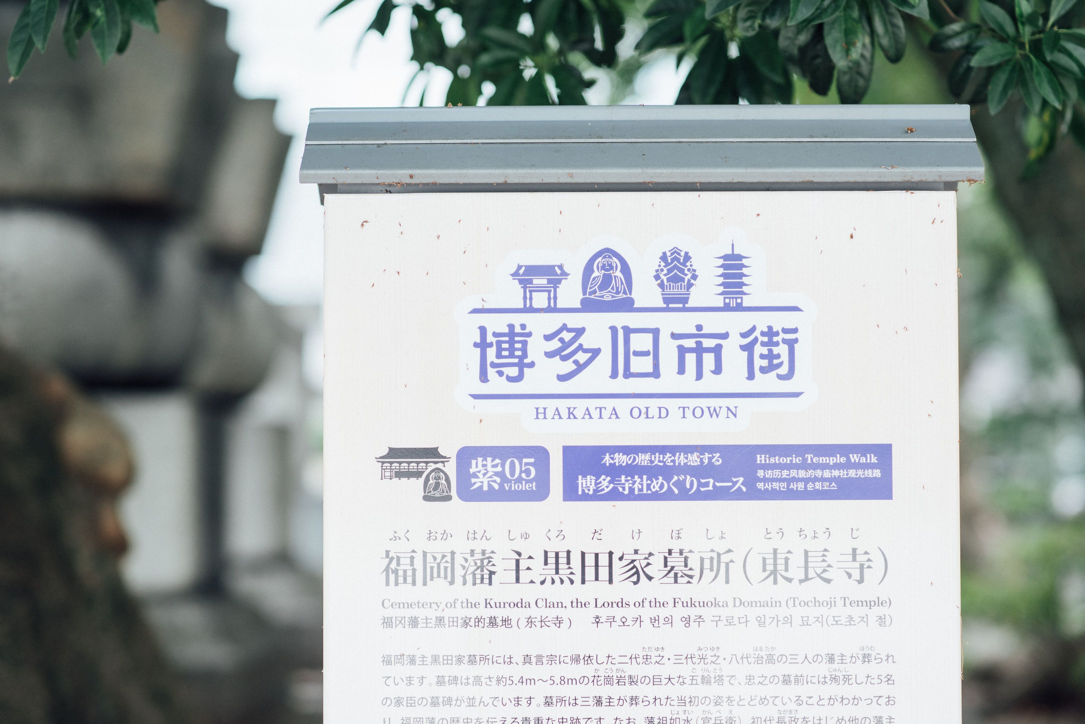 Un cartello con testo e simboli giapponesi che indica un sito storico nella città vecchia di HAKATA.