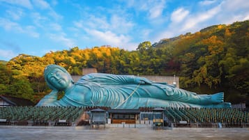 A large reclining Buddha statue in a spacious outdoor area with tiered seating.