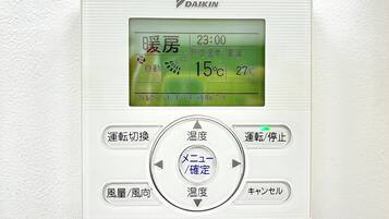 A thermostat with a digital display, control buttons, and a central dial.