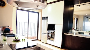 A modern kitchen with a built-in stove, oven, and refrigerator. - Maxshare Hotels & Serviced Apartments (Bai Chay)