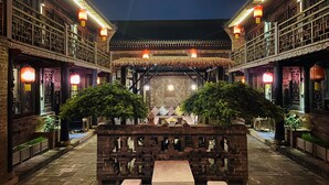 A traditional courtyard with a central seating area, surrounded by brick walls and wooden railings. - Elsewhere Hotel The former residence of the draft bank (Jinzhong)