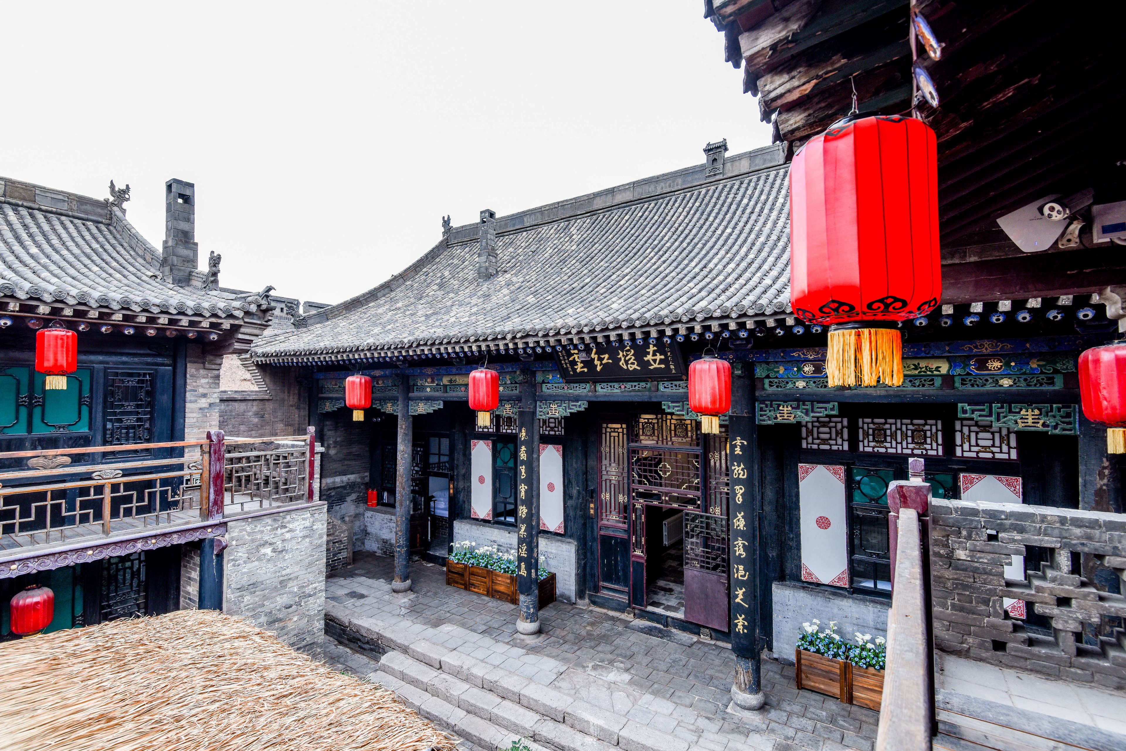 A traditional Chinese building with ornate decorations, a tiled roof, and red lanterns.