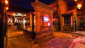 Un edificio tradicional con un letrero que dice 'Meet a World', paredes de ladrillo y una entrada con tejas.