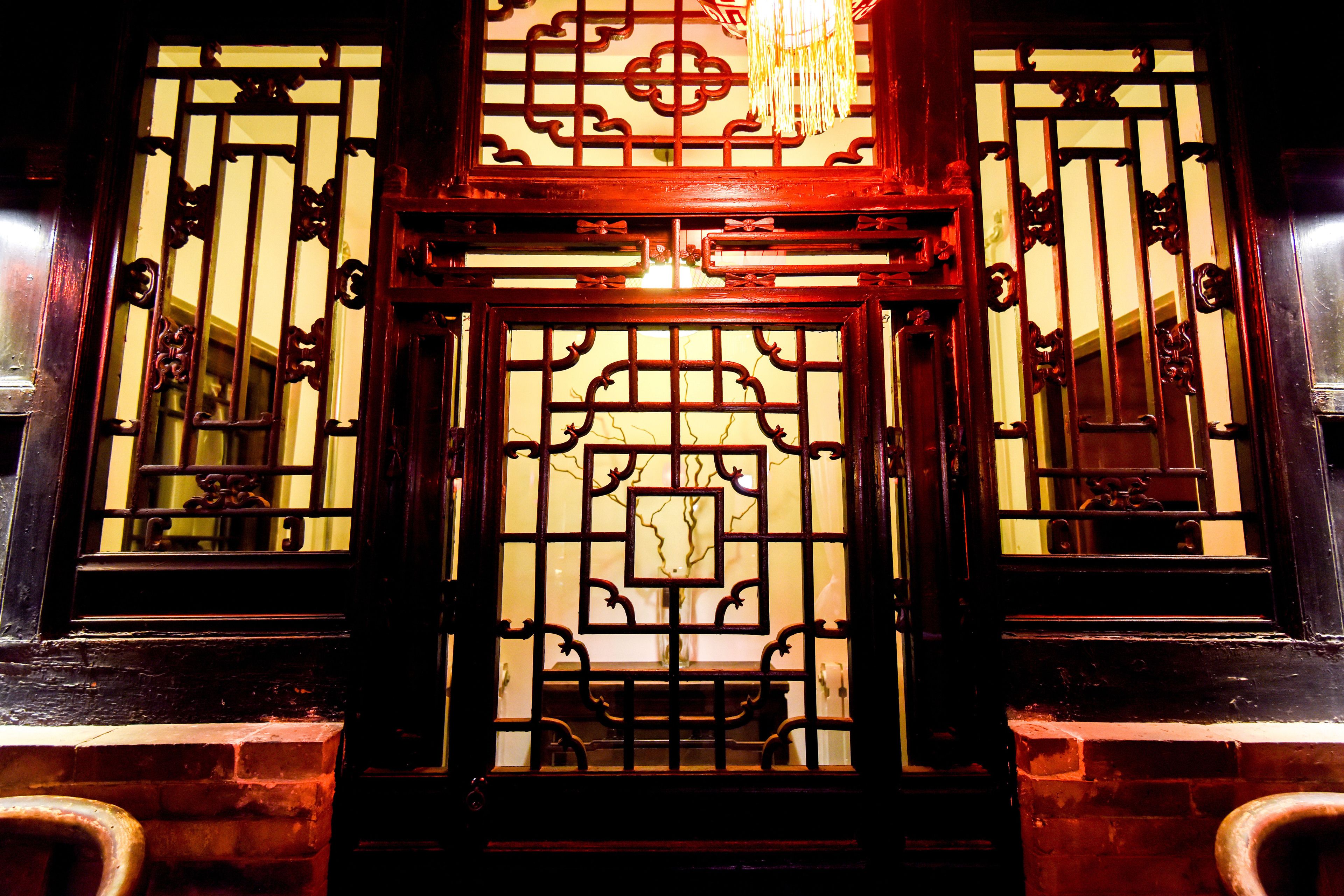 A traditional wooden gate with intricate designs and a central decorative panel.