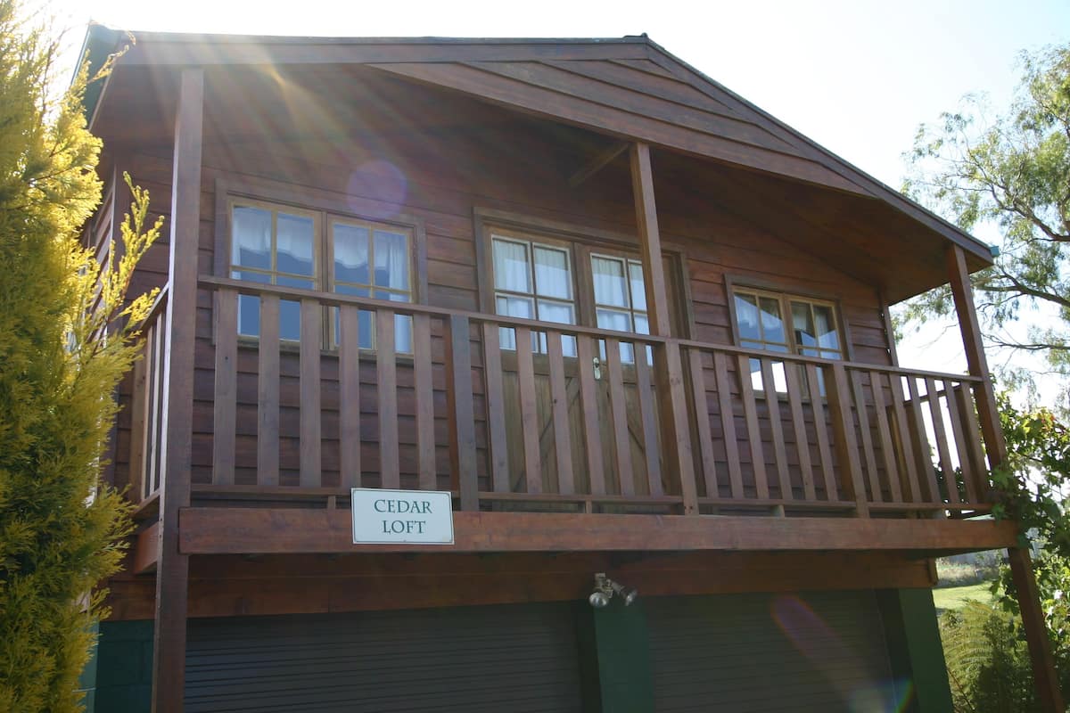 Un bâtiment en bois à deux étages, doté d’un balcon et d’un garage.