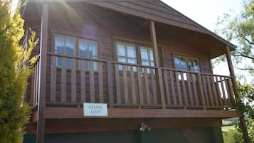 A two-story wooden building with a balcony and a garage.